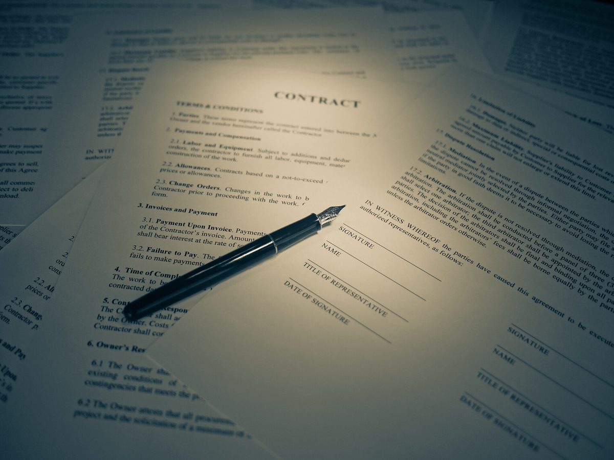 Document semnat cu un stilou, pe un birou